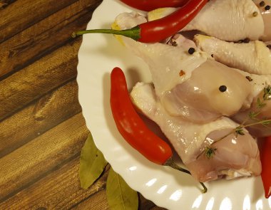 çiğ tavuk ayakları üzerinde bir tabak kırmızı biber