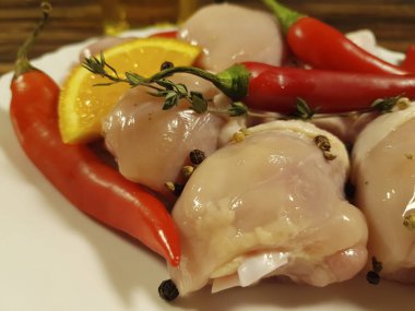 çiğ tavuk ayakları üzerinde bir tabak kırmızı biber