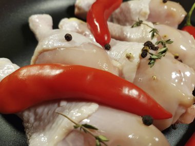 çiğ tavuk ayakları üzerinde bir tabak kırmızı biber