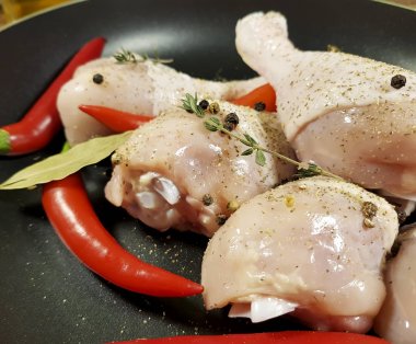 çiğ tavuk ayakları üzerinde bir tabak kırmızı biber