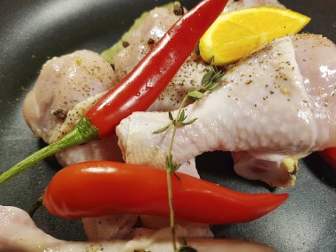 çiğ tavuk ayakları üzerinde bir tabak kırmızı biber