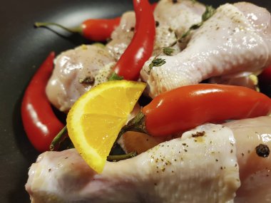 çiğ tavuk ayakları üzerinde bir tabak kırmızı biber