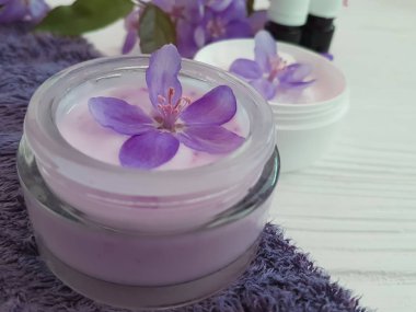 bir tahta üzerinde kozmetik krem pembe çiçekler