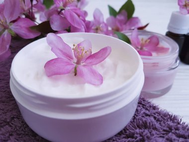 bir tahta üzerinde kozmetik krem pembe çiçekler