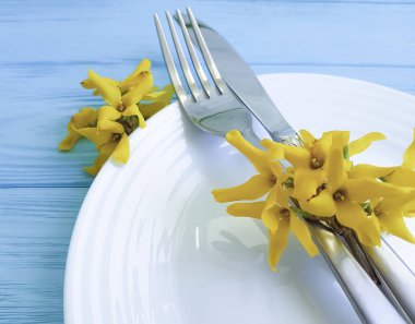 tabak çatal bıçak sarı çiçekler mavi ahşap zemin üzerine