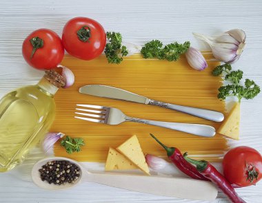 Spagetti sarımsak biber, yağ, bıçak, çatal Beyaz ahşap zemin üzerinde