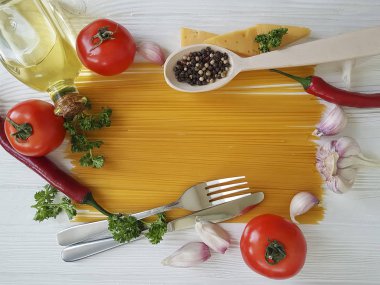 Spagetti sarımsak biber, yağ, bıçak, çatal Beyaz ahşap zemin üzerinde