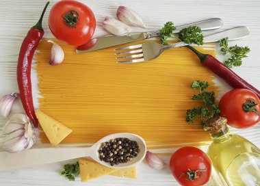 Spagetti sarımsak biber, yağ, bıçak, çatal Beyaz ahşap zemin üzerinde