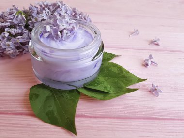 pembe ahşap üzerinde krem kozmetik leylak