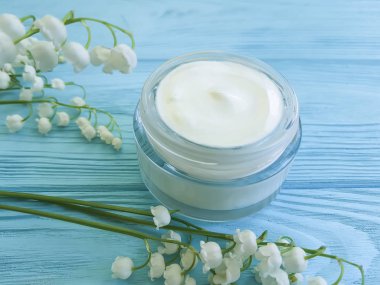 krem kozmetik çiçek lily vadi mavi ahşap zemin üzerine