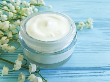 krem kozmetik çiçek lily vadi mavi ahşap zemin üzerine