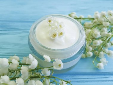 krem kozmetik çiçek lily vadi mavi ahşap zemin üzerine