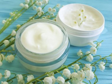 krem kozmetik çiçek lily vadi mavi ahşap zemin üzerine