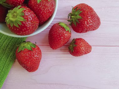 pembe ahşap arka planda taze çilek çanak havlu