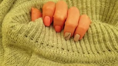 Kadın eli, güzel manikür süveter, yavaş çekim.