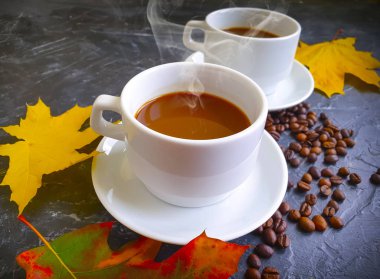 Sonbahar yaprakları beton arka planda bir fincan kahve.