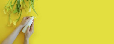 Kozmetik krem, kadın eli, renkli bir arka planda kalla çiçeği