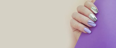 Renkli bir arka planda kadın el manikürü.