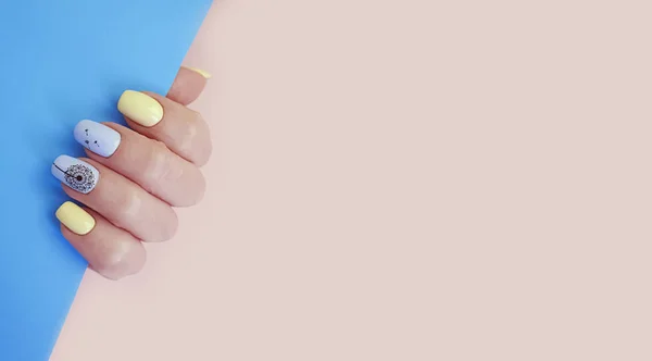 female hand nails beautiful manicure on color paper background