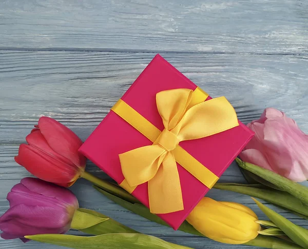 gift box, flower tulip on wooden background