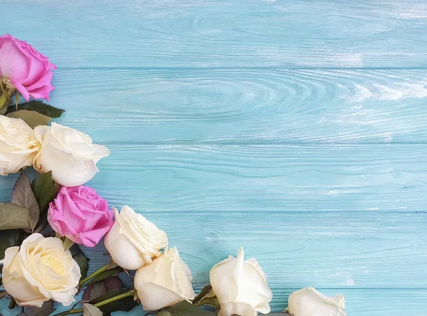 fresh roses frame on wooden background