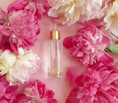 Kozmetik losyon, renkli bir arka planda şakayık çiçeği.