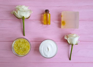 Kozmetik krem, sabun, ahşap arka planda gül çiçeği
