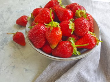 beton bir arka plan üzerinde bir tabak ta taze çilek