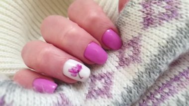 Kadın eli, güzel manikür çiçekli kazak.