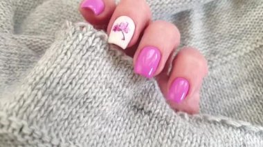 Kadın eli, güzel manikür çiçekli kazak.