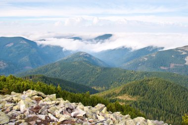 Kabarık beyaz bulutlar ile kaplı tepenin karşı taş