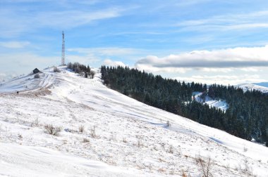 Bir kule ve karlı tepe üzerinde küçük bir ev