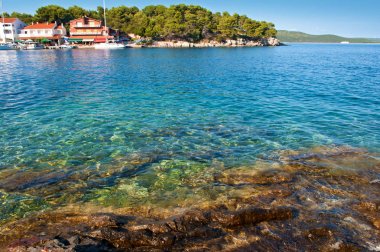 Saydam derin mavi deniz suyu, kayalık sahil 