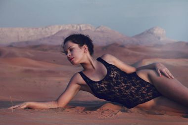 Seksi model Kapalı gözlerle kum üzerinde döşeme