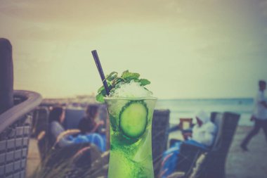 C bir plaj ve mavi gökyüzü bir arka plan üzerine bir bardak Mojito