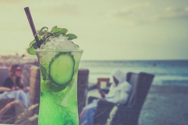 C bir plaj ve mavi gökyüzü bir arka plan üzerine bir bardak Mojito