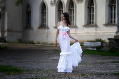 Uzun beyaz bir elbise içinde çekici genç kadın 