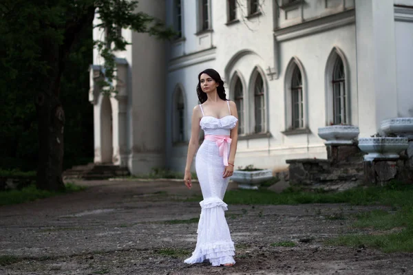 Uzun beyaz bir elbise içinde çekici genç kadın 