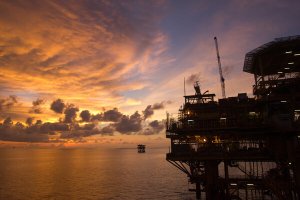 Silhouette of an offshore oil rig at sunset in the South China Sea