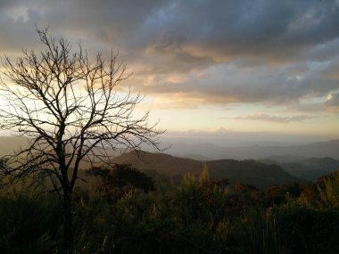 Akşam güneş ışığı ile fantastik gökyüzü bulutlar dağ ve 