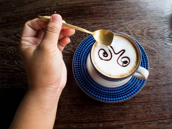 Mano de hombre sosteniendo una cuchara de café con taza de café . — Foto de Stock