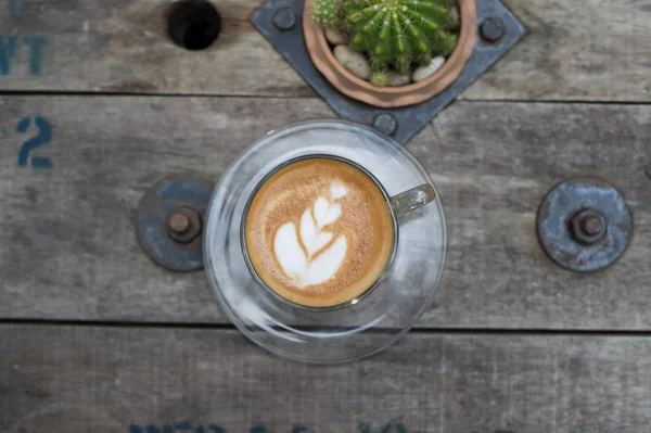 Pohled shora latte art coffee na dřevěný stůl. — Stock fotografie