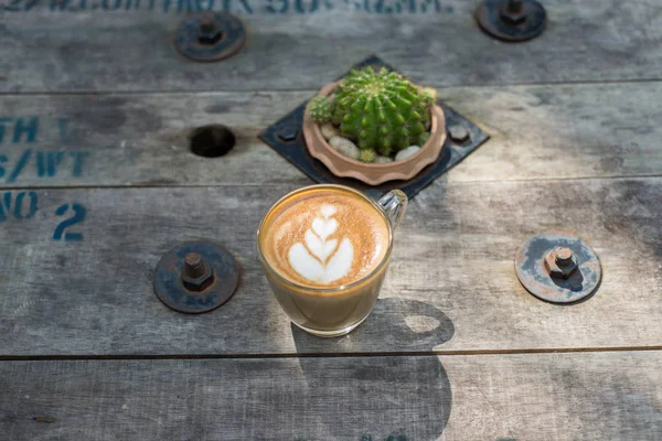 Pohled shora latte art coffee na dřevěný stůl. — Stock fotografie