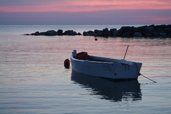 a white fishing boat during the sunrise