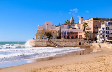 Beach on a background of not a calm sea and the old town clipart