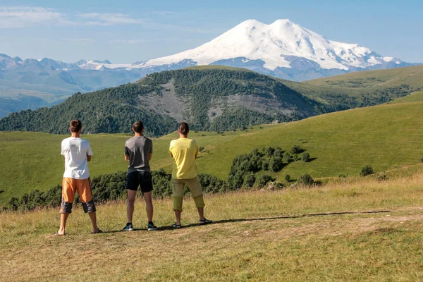 Three men enjoy the view of the mountain before the future ascen — Stock Photo, Image