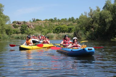 Mygiya, Ukrayna - 06 04 2017: bir akıllı telefon ile kız arkadaş şirket içinde bir kayık yüzüyor. Pivdennyi Buh nehirde rafting