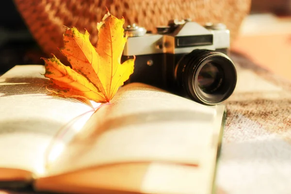 Maple leaf , book and old film camera on autumn background. Diary , an old camera , and a scarf on table with autumn leaves and sunlight — Stock Photo, Image