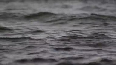 Düşük dalgalı güzel mavi deniz suyu yüzeyi. Deniz manzaralı arka plan. Sakin Kara Deniz Dalgaları. Yakın çekim, sığ odak. Düşük ışık