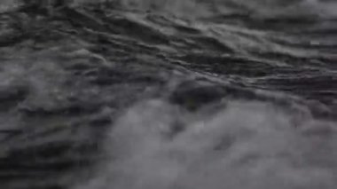 Düşük dalgalı güzel mavi deniz suyu yüzeyi. Deniz manzaralı arka plan. Sakin Kara Deniz Dalgaları. Yakın çekim, sığ odak. Düşük ışık